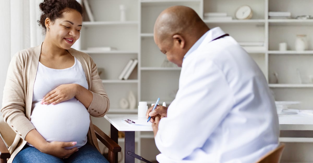 Un médecin qui rédige une prescription pour sa patiente enceinte