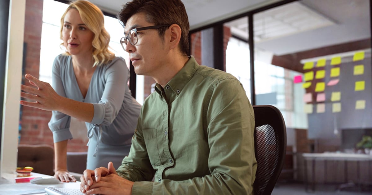 Une pharmacienne et un programmeur devant un écran d'ordinateur