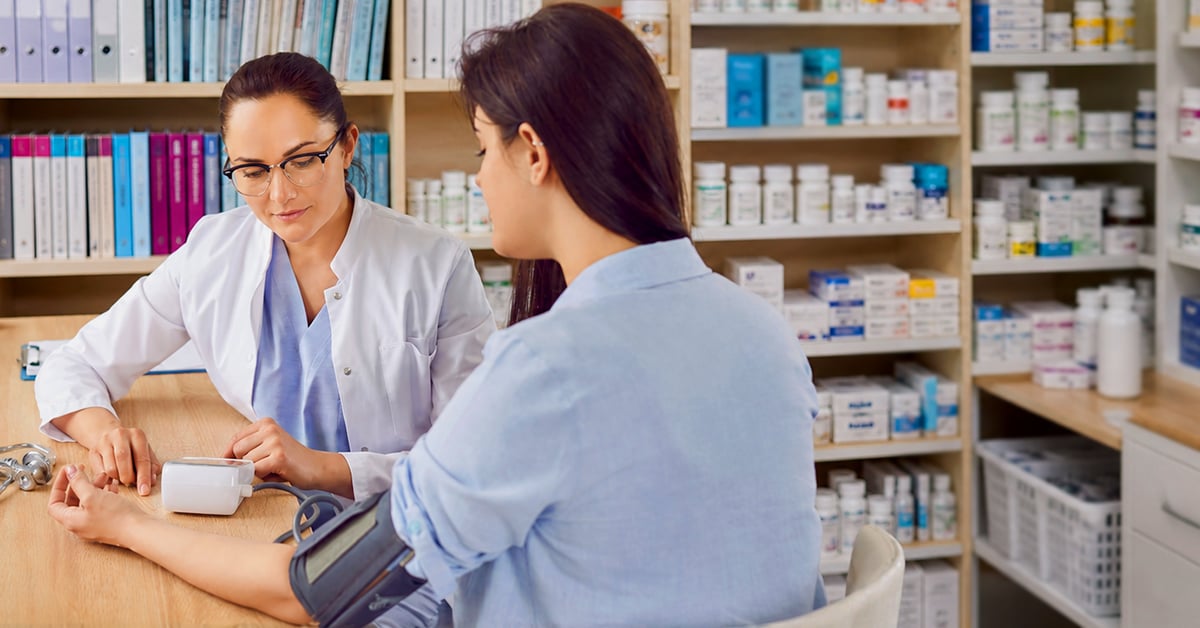 A pharmacist checking a patient's blood pressure