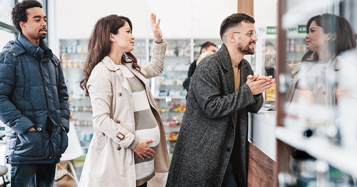 Plusieurs personnes qui attendent impatiemment au comptoir de pharmacie.