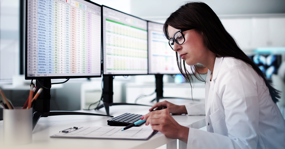 A healthcare professional managing data on a computer.