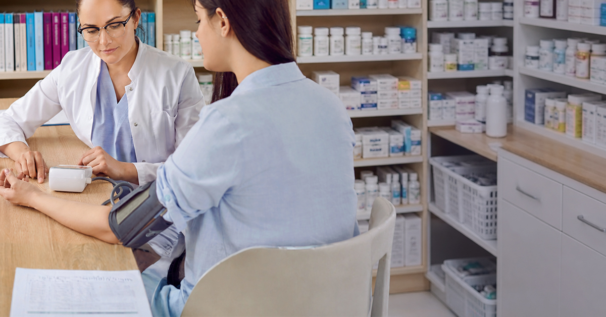 A pharmacist checking a patient's blood pressure