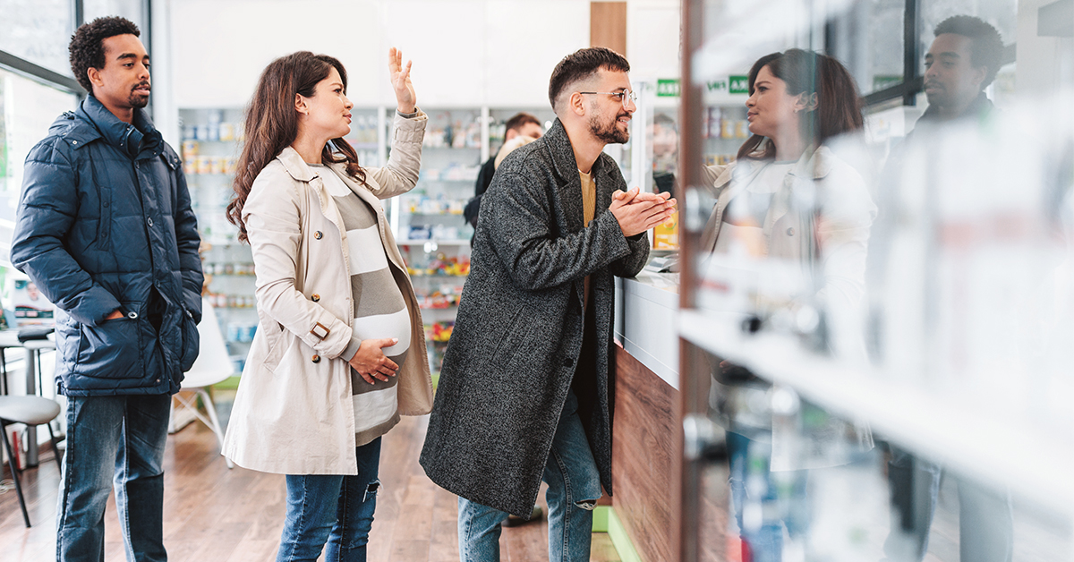 Several people waiting impatiently at the pharmacy counter.